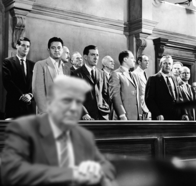 Donald Trump seated in front of the jury from the movie 12 Angry Men