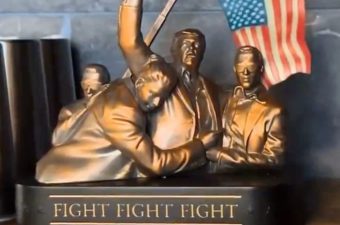 A sculpture of Donald Trump with fist raised, saying fight fight fight.