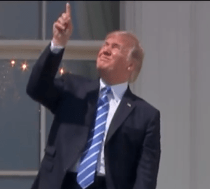 Donald Trump looks at a solar eclipse without protective glasses